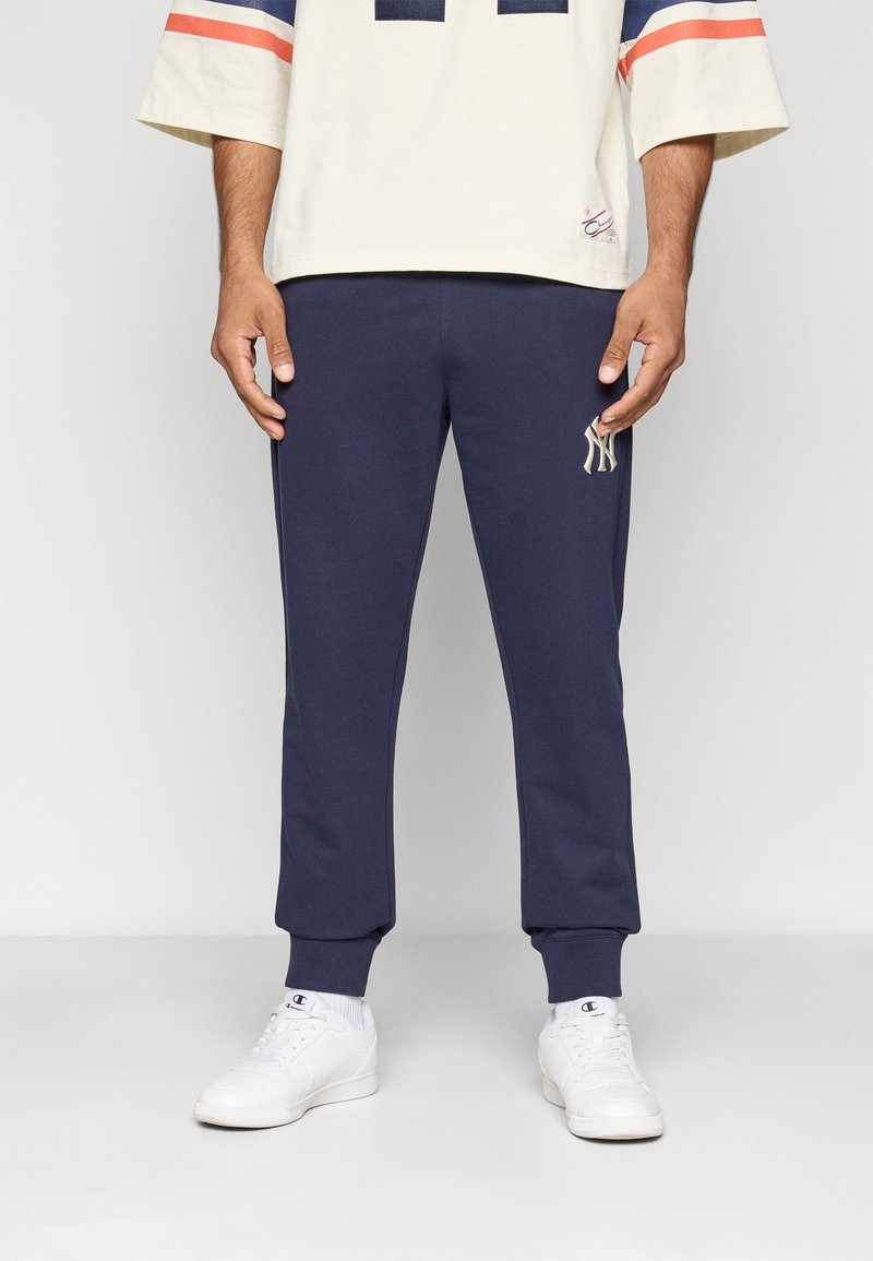 Marineblauwe joggingbroek van een zachte katoenmix met elastische cuffs, voorzien van een klein wit logo op de linkerdij en zijzakken.