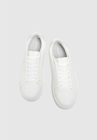 Białe sneakersy wykonane z gładkiego materiału syntetycznego, z zaokrąglonym noskiem, sznurowanym zapięciem i wyściełanym wnętrzem, z logo na języku.