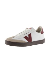 Sneaker in pelle bianca con accenti bordeaux, punta beige e suola in gomma testurizzata; presenta lacci tradizionali e dettaglio del logo sulla linguetta.