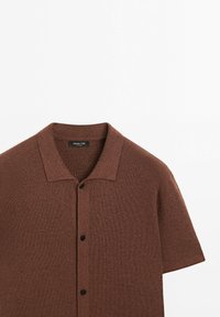Brown ribbed short-sleeve button-up shirt with a pointed collar, shown on a plain white background.