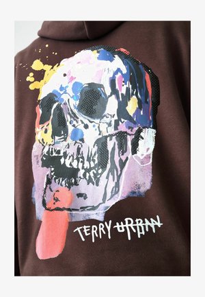 Brązowa bluza z kapturem z kolorowym nadrukiem czaszki i plamami farby. Projekt zawiera czarne akcenty oraz biały napis „TERRY URBAN”.