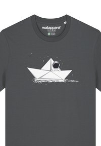 Grijze t-shirt met een witte afbeelding van een papieren boot met een astronaut, omringd door sterren en watergolven.