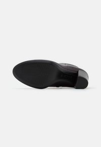 Suola in gomma nera con grip testurizzato, dotata di un leggero tacco e tomaia in pelle bordeaux liscia, progettata per comfort e durata.
