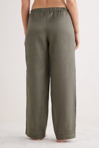 Olijfgroene linnen wijde broek met een elastische tailleband, voorzien van een gladde textuur en een rechte snit, met omgeslagen onderkant.