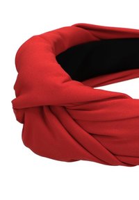 Czerwona opaska na głowę z zaplatanym wzorem. Gładka tekstura, elastyczny materiał i kontrastowe czarne wnętrze. Brak widocznych elementów metalowych lub wzorów.