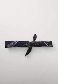 Marineblå stoffhodebånd med et blomsterdesign i hvitt, med en knyttedetalj i midten for sikker bruk.
