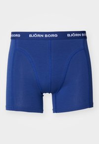 Kék boxer nadrág puha anyagból, fehér BJÖRN BORG logós derékkal, szoros illeszkedéssel és sima, varrás nélküli kialakítással.