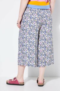 Pantaloni culotte floreali in blu, caratterizzati da un motivo di fiori rosa, gialli e bianchi. Il design include una vestibilità ampia e una lunghezza cropped.
