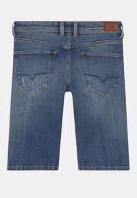 Shorts en denim bleu moyen, avec une coupe droite, cinq poches et un patch en cuir de la marque sur la taille. Détails usés sur les poches arrière.