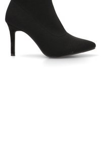 Botín de tacón alto de punto negro con puntera afilada, tacón de aguja delgado y textura suave, con un diseño sin costuras.