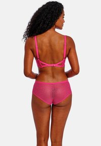 Conjunto de lencería fucsia que incluye un sujetador de encaje con tirantes ajustables y pantalones cortos a juego, que exhiben un delicado patrón floral y una textura suave.