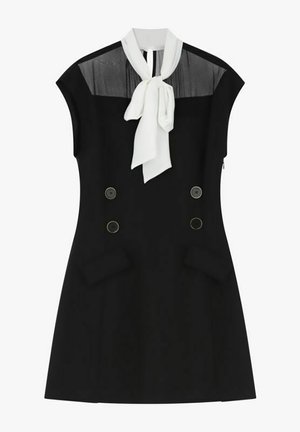 Abito nero senza maniche con pannello superiore trasparente, bottoni doppiopetto, tasche a pattina e dettaglio con cravatta bianca al collo.