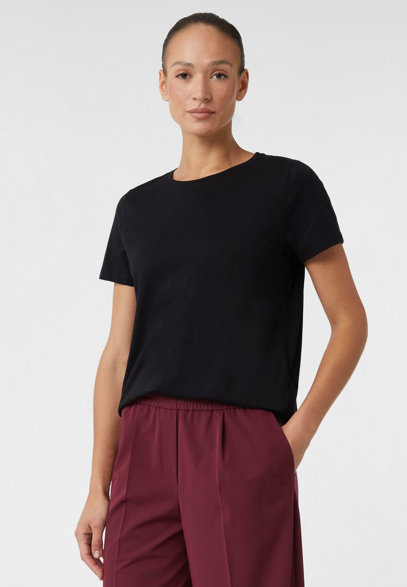 Zwarte t-shirt met korte mouwen en een ronde hals, gemaakt van zachte stof, gecombineerd met bordeauxrode broek met een relaxed fit en een elastische taille.