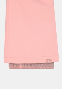 Giacca impermeabile rosa con una texture liscia, dotata di polsini elasticizzati e un'etichetta cucita con "ROXY". Design minimalista, senza motivi.
