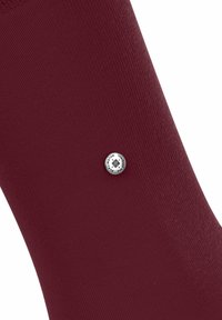 Chaussette bordeaux avec un motif texturé, arborant un petit logo rond près du bord. Un design simple et élégant.