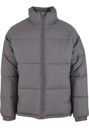 Graue Pufferjacke mit hohem Kragen, Reißverschluss, gestepptem Material und elastischen Bündchen. Die Vorderseite hat horizontale Nähte zur Isolierung.
