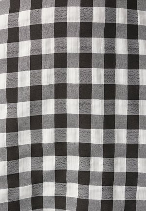 Tela de patrón de cuadros vichy en blanco y negro con un diseño de tablero de ajedrez, que presenta tamaños de cuadrados contrastantes para añadir textura e interés visual.