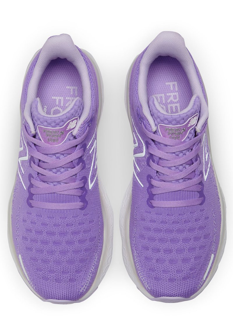 Zapatillas deportivas moradas con parte superior de malla, diseño texturizado y acentos blancos. Las características incluyen cordones y una suela acolchada.