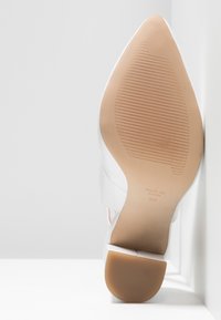 Semelle d'une chaussure blanche à bout pointu avec semelle extérieure beige rainurée et petit talon bloc, taille 37, fabriquée en Espagne.