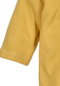 Kurzärmliges Oberteil aus senfgelbem Stoff, mit weicher Textur und genähtem Saumdetail. Einfaches, minimalistisches Design ohne Muster.