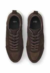 Sneaker marroni con lacci realizzati in suede e materiale testurizzato, con suola in gomma bianca e logo in rilievo sulla linguetta.