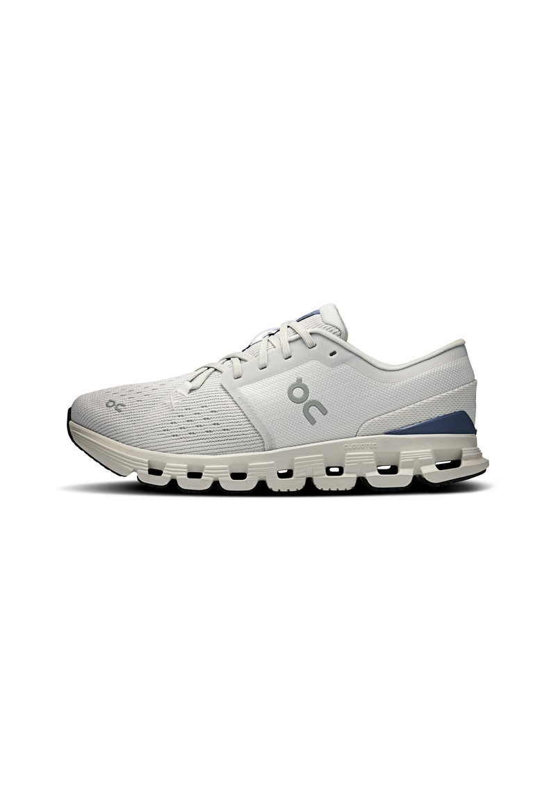 Light gray athletic shoe with a textured upper, lace design, and cushioned sole featuring multi-shaped cutouts. Accent in darker gray.