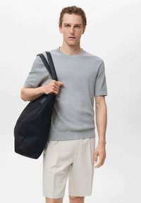 Gray ribbed knit shirt, cream shorts, and a large black tote bag with a soft texture and long shoulder straps. Simple and modern design.
