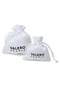 Bijele torbe s vezicom različitih veličina s natpisom "VALERO PEARLS" ispisanim crnom bojom. Meki materijal s glatkom teksturom i zaobljenim oblikom.