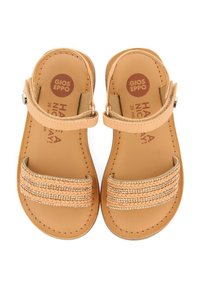 Sandalias de color marrón claro con suela plana, que cuentan con dos tiras trenzadas y detalles decorativos en las correas. Hebilla ajustable en un lado.