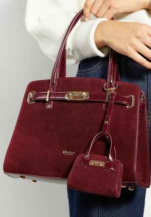 Burgundy suede handbag with polished leather accents, dual handles, and a small matching bag attached, featuring gold hardware and logo detail.
