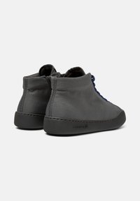 Zapatillas altas gris con parte superior de tela texturizada y suela de goma oscura, que cuentan con un cierre de cordones azul y un zipper en la parte posterior.