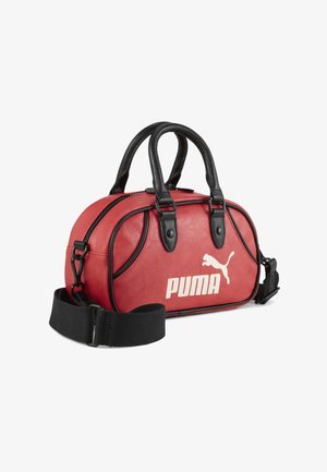 Sac à main synthétique rouge avec des accents en cuir noir, anses supérieures, bandoulière réglable et un grand logo Puma blanc à l'avant.