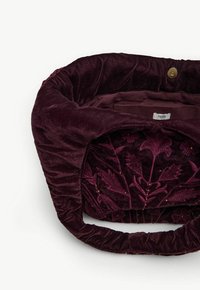 Bordeaux fluwelen handtas met bloemembroderie, zachte textuur en een geplooide handgreep. Interieur gevoerd met effen bordeauxkleurige stof.