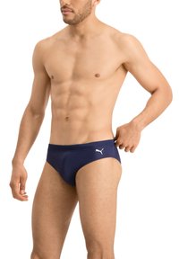Dunkelblaue Schwimmbrieft mit glatter Textur, versehen mit einem weißen Logo auf der linken Seite, entworfen mit einem niedrigen Bund und minimaler Abdeckung.