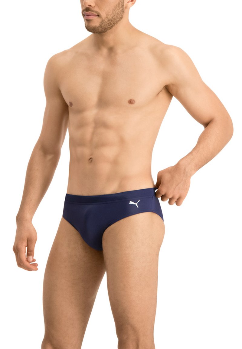 Dunkelblaue Schwimmbrieft mit glatter Textur, versehen mit einem weißen Logo auf der linken Seite, entworfen mit einem niedrigen Bund und minimaler Abdeckung.