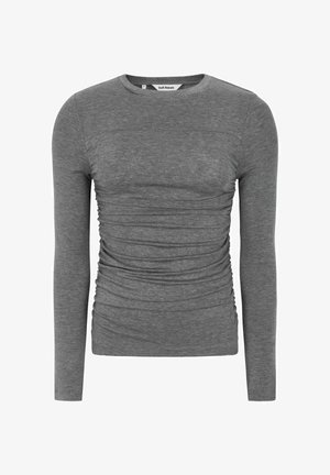 Siva dolgi rokav T-shirt iz mehkega materiala, ki se ponaša z nabranimi detajli ob straneh in okroglim izrezom. Preprost dizajn s prilegajočo silhueto.