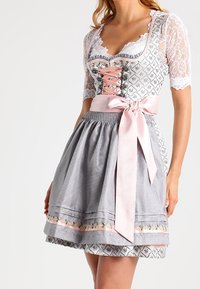 Dirndl traditionnel avec des manches en dentelle, jupe à carreaux gris et blancs, ruban en satin rose à la taille, broderie florale à l'ourlet.