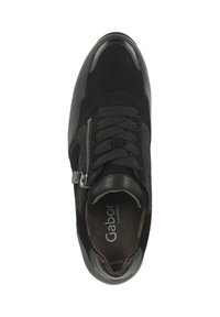 Baskets noires combinant daim et cuir, avec bout rond, lacets et une fermeture éclair décorative sur le côté.