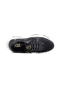Zapatilla negra con parte superior de malla, acentos de plástico, cordones redondos y suela de goma blanca. La plantilla muestra un logotipo de la marca.