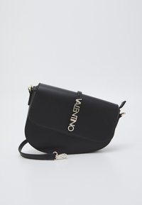 Black leather crossbody bag with gold hardware, featuring a front flap closure and a prominent logo accent. Smooth texture, curved shape.