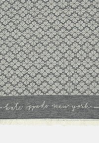 Gray fabric featuring a repetitive floral pattern in light gray, with a frayed edge and "kate spade new york" text at the bottom.