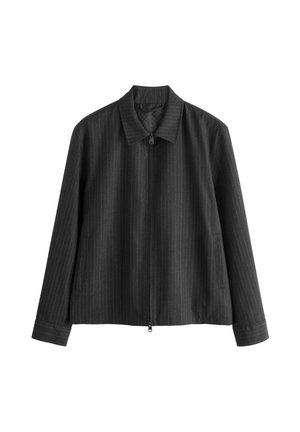 Czarna kurtka na zamek z delikatnymi pionowymi prążkami, długimi rękawami, kołnierzykiem i bocznymi kieszeniami, przedstawiona na białym tle.