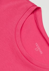 Fuchsiová pink bavlněná tričko s kulatým výstřihem, hladkou texturou a viditelnou značkovou etiketou, zdůrazňující jeho živou barvu.