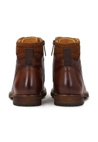 Botas de cuero marrón hasta el tobillo con acentos de ante, cremalleras laterales y puntera redondeada. Textura suave con una suela de madera y tacón reforzado.