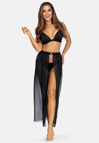 Czarny bikini z dekoltem w kształcie litery V, z przejrzystą czarną maksiówką z wysokim rozcięciem i elastycznym pasem w talii, eksponującą skórę pod spodem.