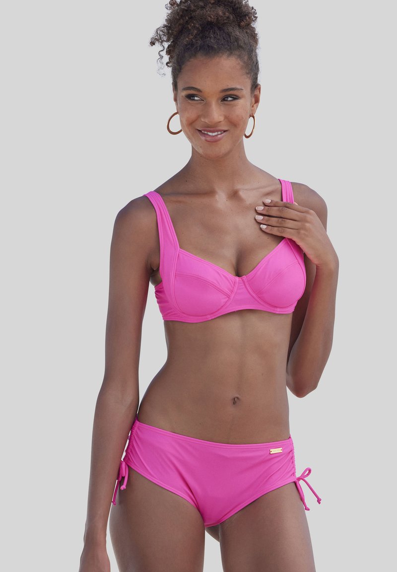 Różowy zestaw bikini z usztywnionym topem z szerokimi ramiączkami, fiszbinami oraz wiązaniami po bokach dolnej części bikini, wykonany z gładkiego materiału.