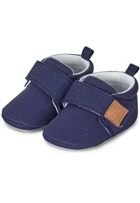 Navy blue canvas shoes with a soft white lining, Velcro strap, oval toe design, and a small brown leather accent on the side.