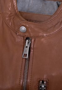 Braune Lederjacke mit sichtbarem Metallreißverschluss, Druckknopf und einem genähten Kragen. Glatte Textur mit leichtem Glanz.