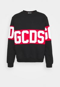 Sweat-shirt noir avec une large bande rouge traversant la poitrine et les manches, ornée de grandes lettres blanches GCDS.