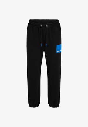 Pantalones de chándal negros con cintura elástica, cordones de contraste en azul y un parche gráfico azul con texto en el muslo izquierdo.